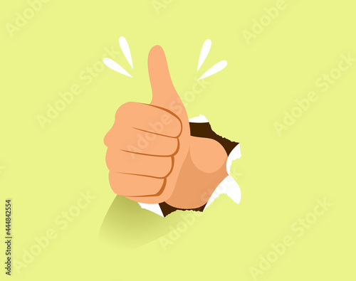Male hand making thumb up gesture through paper hole