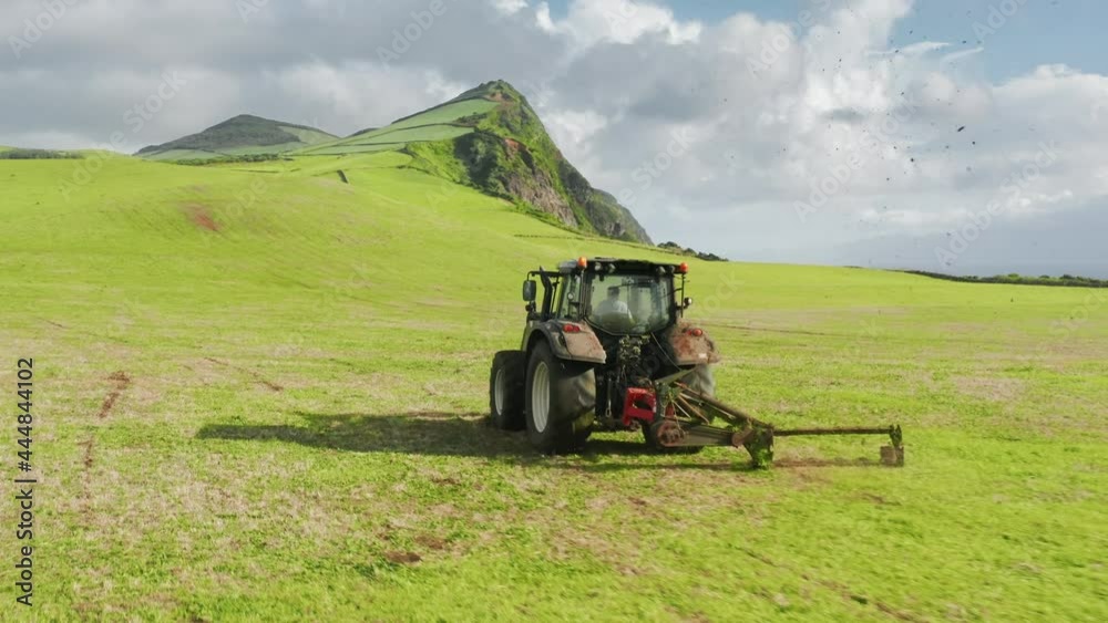 Tractor cultivating crops on farm fields of Sao Jorge island, Azores, Portugal Tractor cultivating crops on farm fields of Sao Jorge island, Azores, Portugal