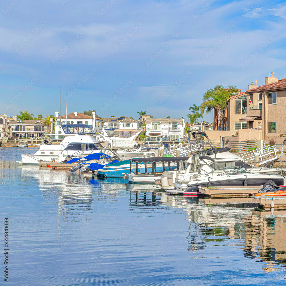 Square Boats docked at the harbour with waterfront homes in Huntington Beach California