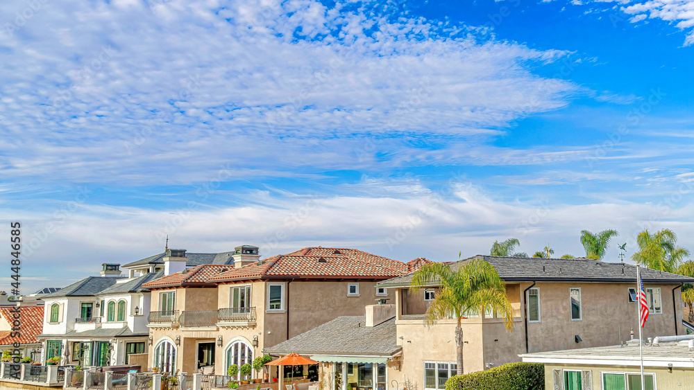 Fototapeta Pano Blue sky and clouds over homes at the prestigious community of Huntington Beach
