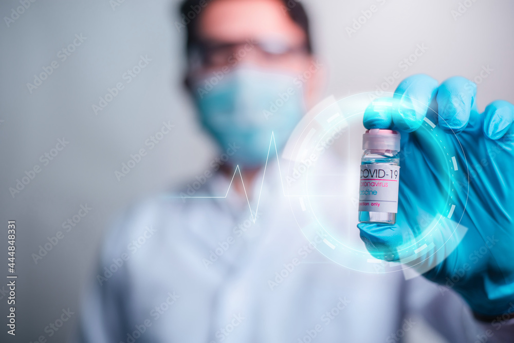 Doctor holding vaccine bottle with modern HUD interface screen on hospital background, Innovation and Medical technology. Doctor holding vaccine bottle with modern HUD interface screen on hospital background, Innovation and Medical technology.