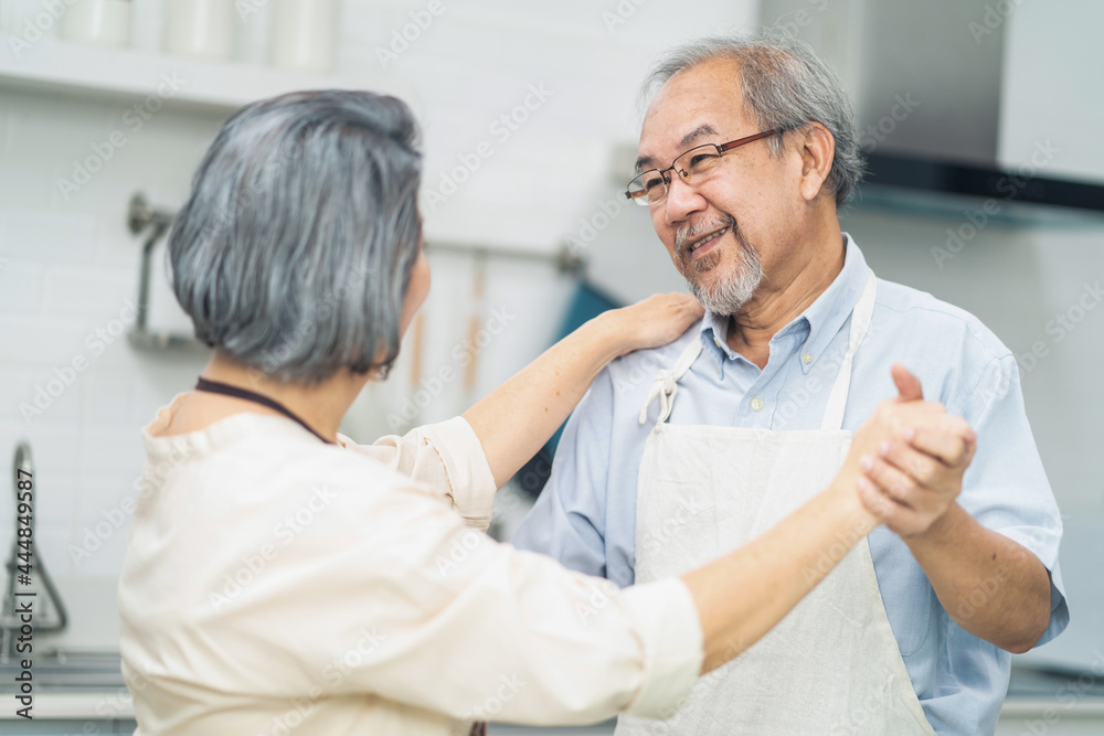 Fototapeta premium Asian romance senior elderly couple stay at home enjoy cook in kitchen.