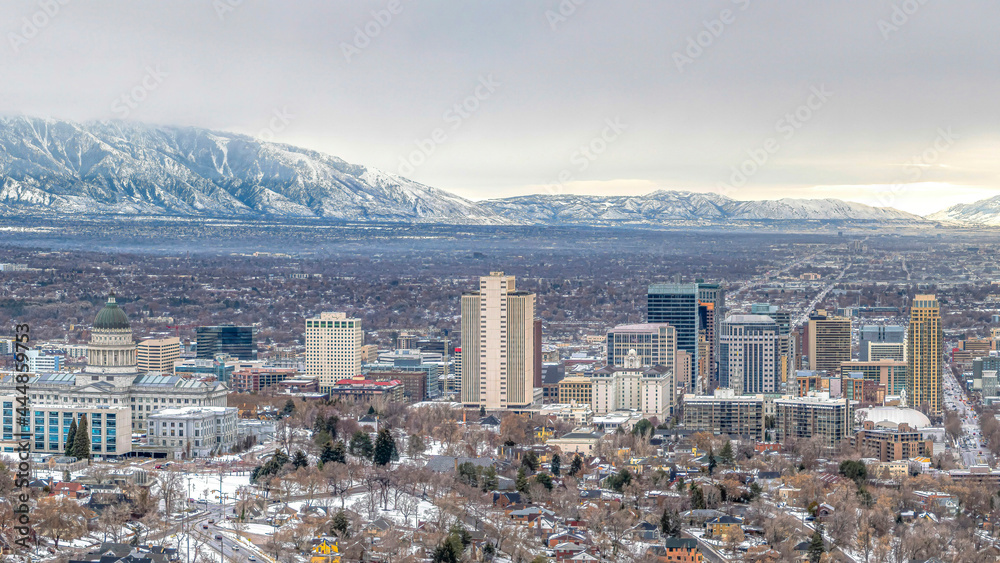 Pano Panorama of Salt Lake City with snowy mountain and gray cloudy sky in winter
