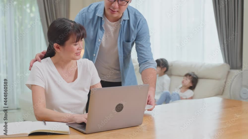 Asian Loving husband taking care of beautiful wife while work at home. Asian Loving husband taking care of beautiful wife while work at home.