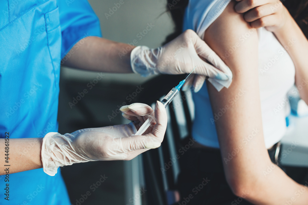 Close up photo of the vaccination process. Woman is vaccinated with serum from coronavirus. - obrazy, fototapety, plakaty 