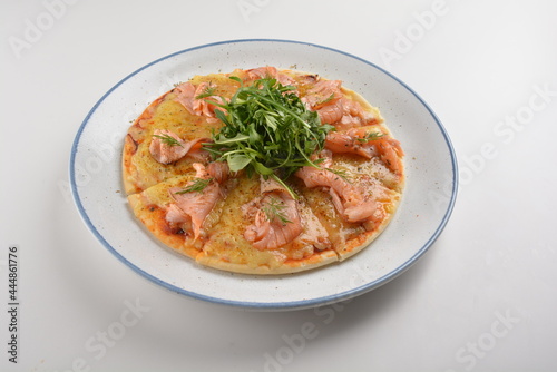 baked cheesy pizza with smoked salmon seafood and salad in white background western halal menu