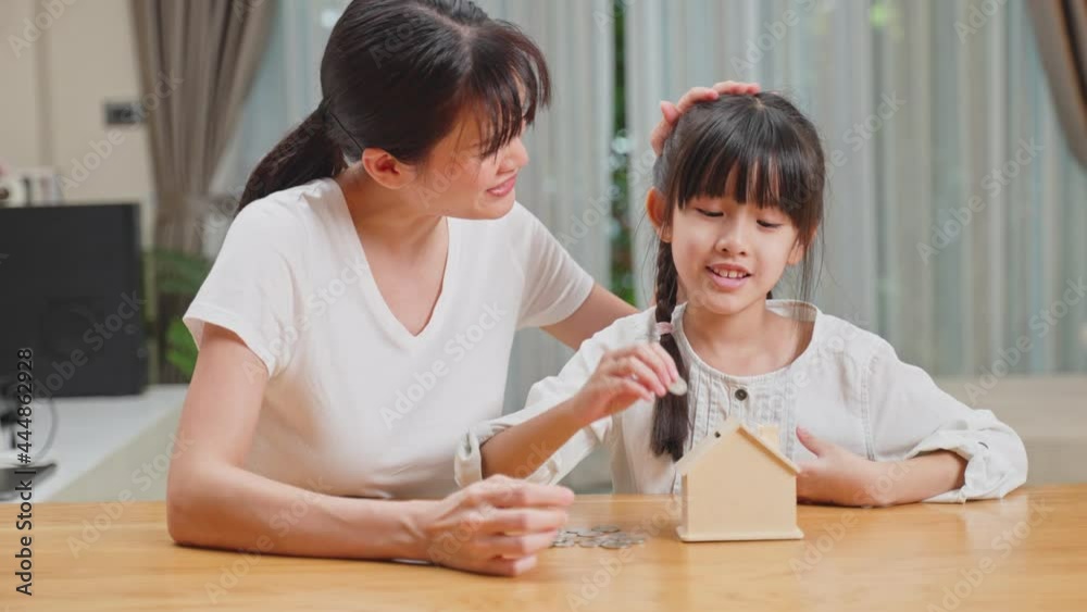 Asian Loving Mother teach young child daughter save money for future. Asian Loving Mother teach young child daughter save money for future.