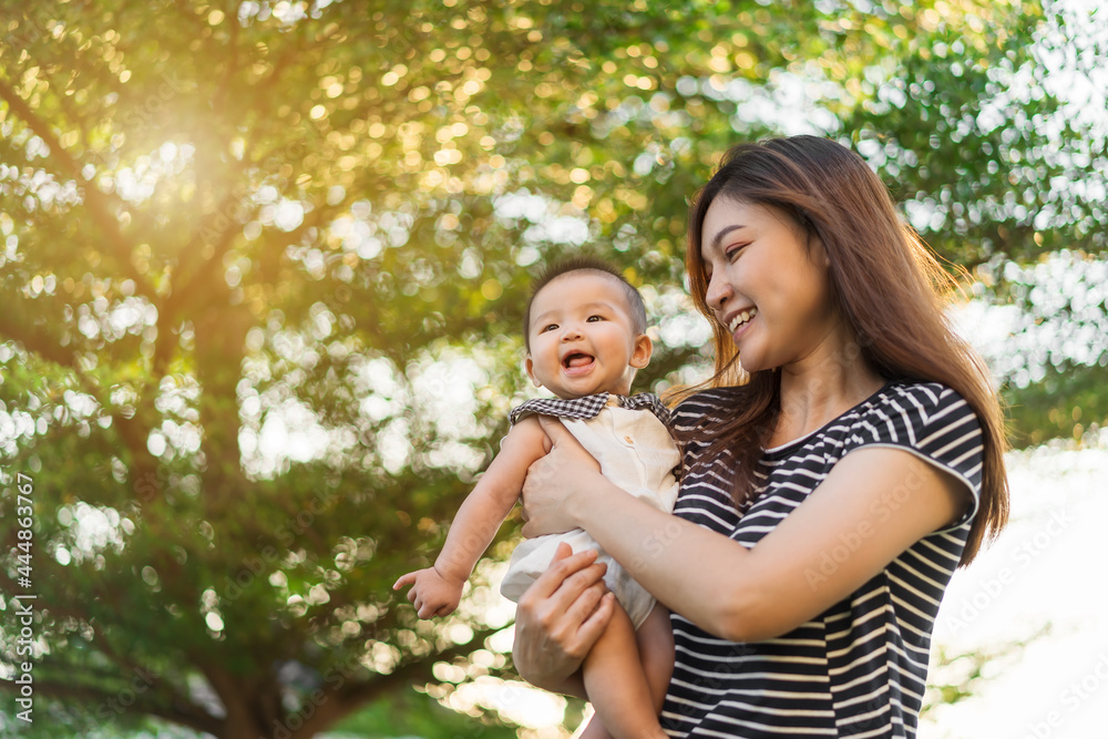 happy mother holding newborn baby in a tender embrace on green nature bokeh background with sunlight happy mother holding newborn baby in a tender embrace on green nature bokeh background with sunlight