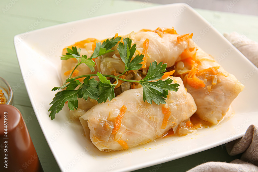 Plate with tasty stuffed cabbage rolls on color wooden background Plate with tasty stuffed cabbage rolls on color wooden background