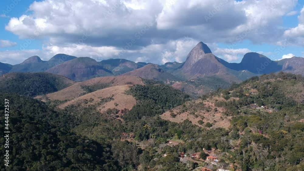 Aerial view of Itaipava, Petrópolis. Mountains with blue sky and some clouds around Petrópolis, mountainous region of Rio de Janeiro, Brazil. Drone photo. Sunny day. Aerial view of Itaipava, Petrópolis. Mountains with blue sky and some clouds around Petrópolis, mountainous region of Rio de Janeiro, Brazil. Drone photo. Sunny day.