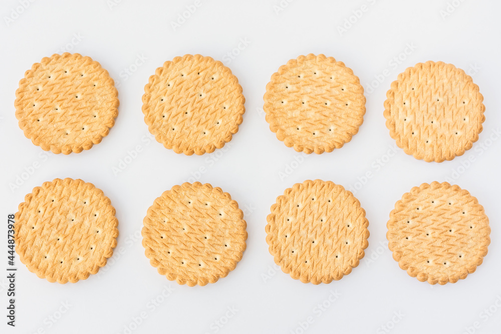 Round cookie white background top view. Eight light yellow crackers lie in two rows. A food texture with space for text. Creative cooking template. Unsweetened wheat biscuits. Crunchy breakfast Round cookie white background top view. Eight light yellow crackers lie in two rows. A food texture with space for text. Creative cooking template. Unsweetened wheat biscuits. Crunchy breakfast