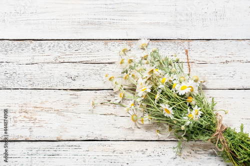 Bouquet of beautiful chamomile flowers on light wooden background © Pixel-Shot