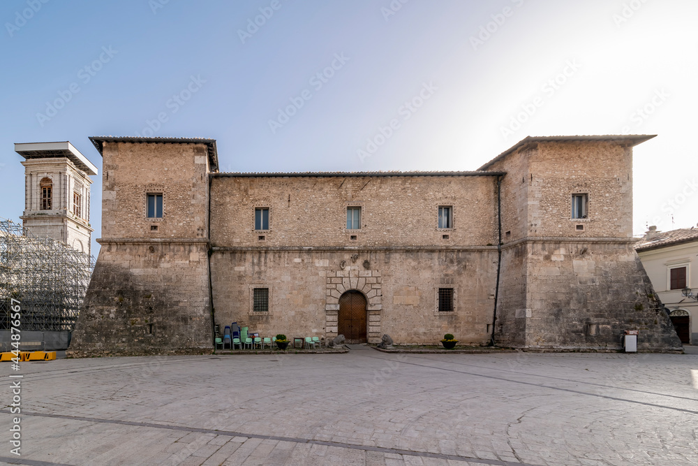 The facade of the ancient La Castellina palace and the bell tower of the cathedral, Norcia, Italy