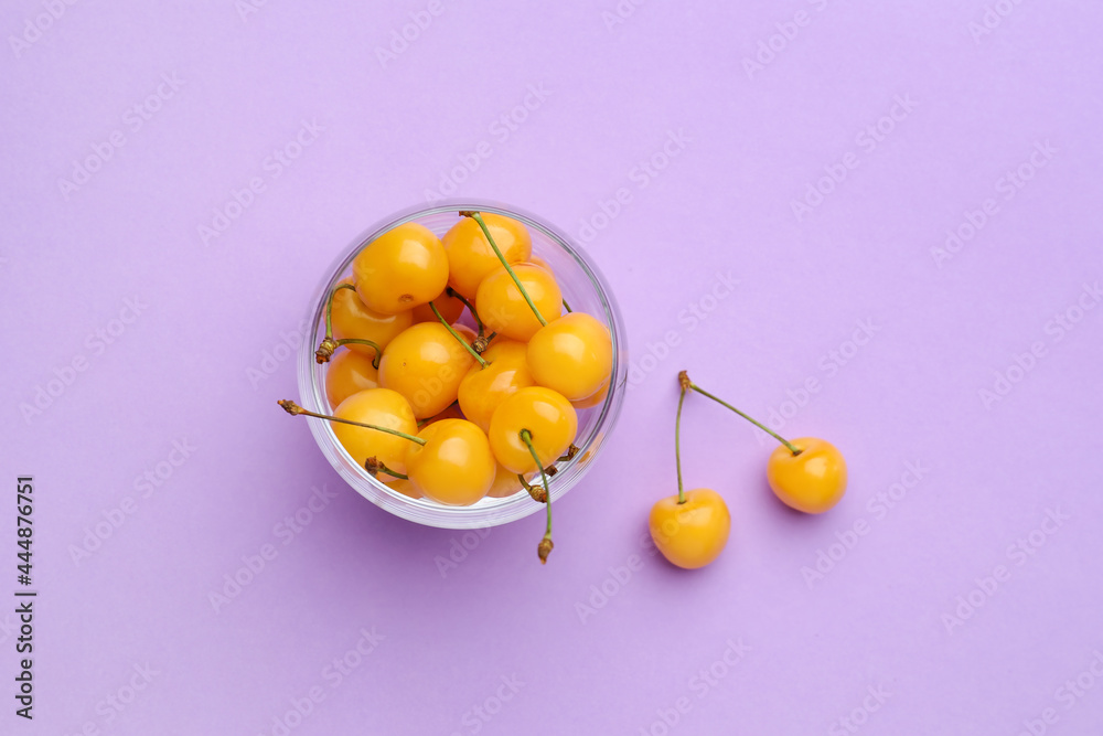 Bowl with tasty sweet cherries on color background