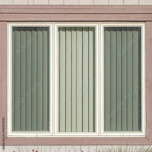 Square Window with three glass panes at house exterior in Huntington Beach California