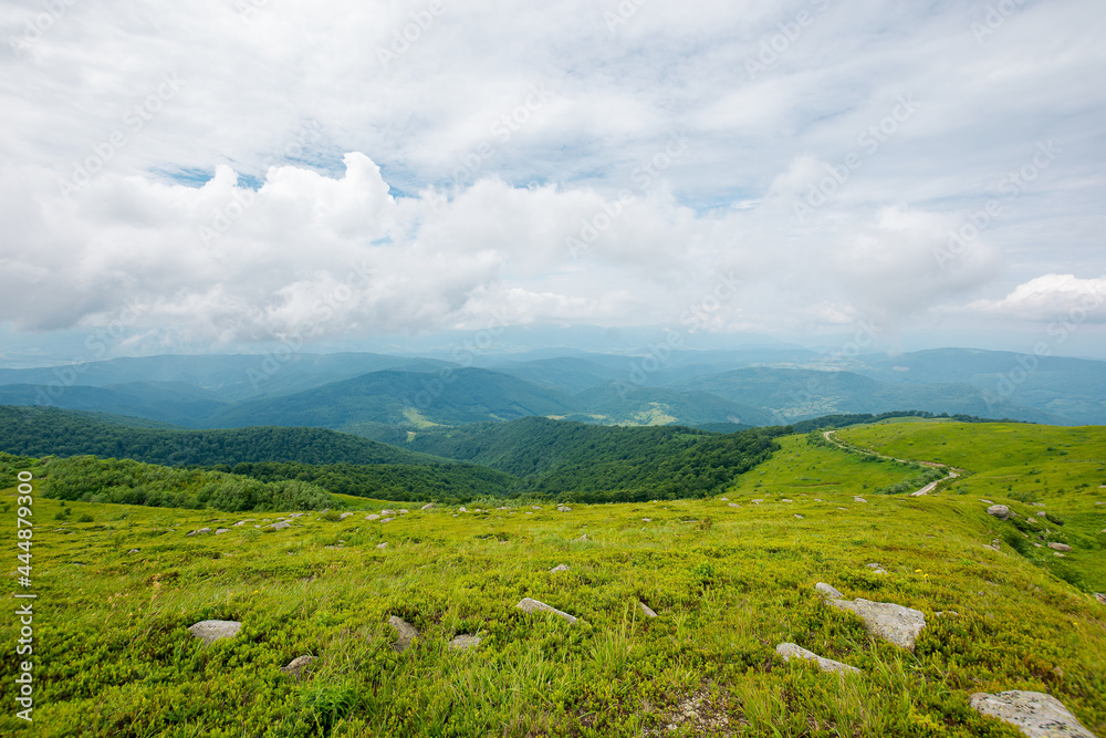 green nature landscape. beautiful summer scenery in mountains. stones on the grassy hills rolling in to the distant ridge beneath a cloudy sky green nature landscape. beautiful summer scenery in mountains. stones on the grassy hills rolling in to the distant ridge beneath a cloudy sky