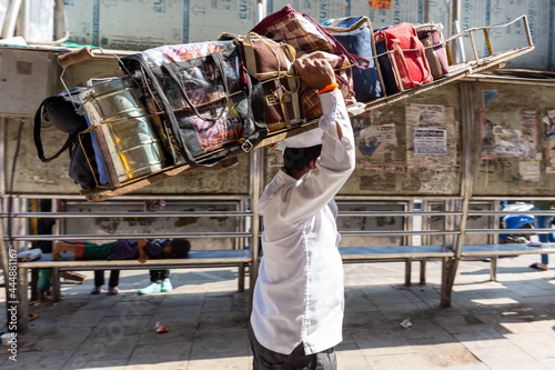 Mumbai, India, 18 november, 2019. Dabbawala lunchbox delivery service: operators with typical white hat delivering lunchboxes with warm homemade food. Operators transporting the lunchboxes.