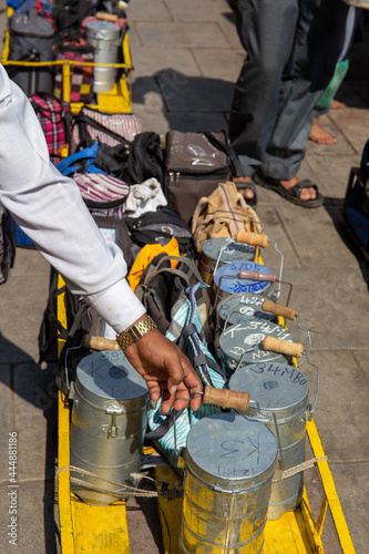 Mumbai, India, 18 november, 2019. Dabbawala lunchbox delivery service: operators with typical white hat delivering lunchboxes with warm homemade food. Operators sorting the lunchboxes. © laura