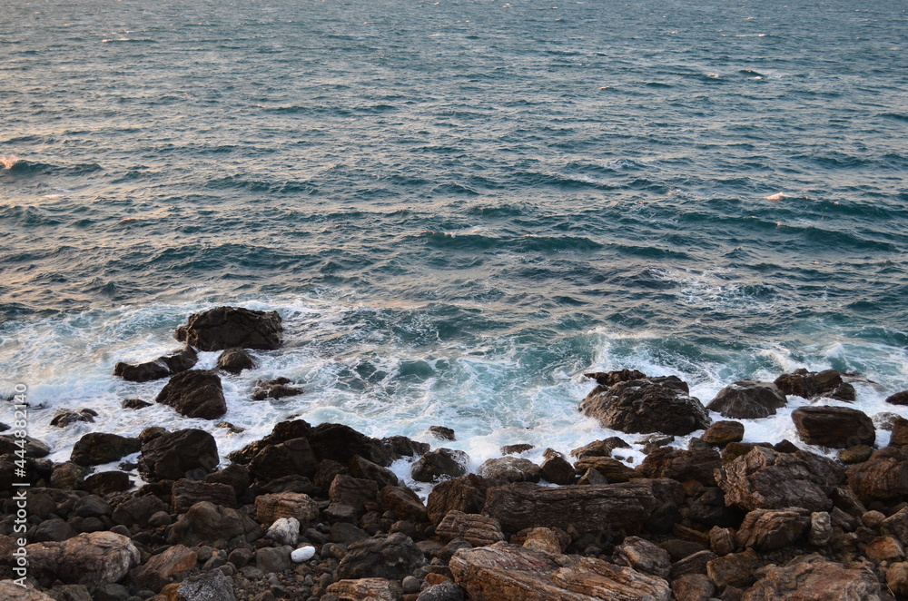 Fototapeta premium The unquiet landscape of rocks and the sea. Splashes of waves are shaving rock