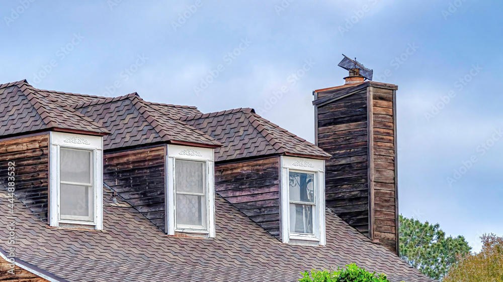 Pano Dormer windows on gray roof of house with chimney in San Diego California Pano Dormer windows on gray roof of house with chimney in San Diego California