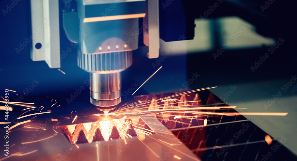 CNC Laser engraving cutting of heavy metal with light spark. Concept