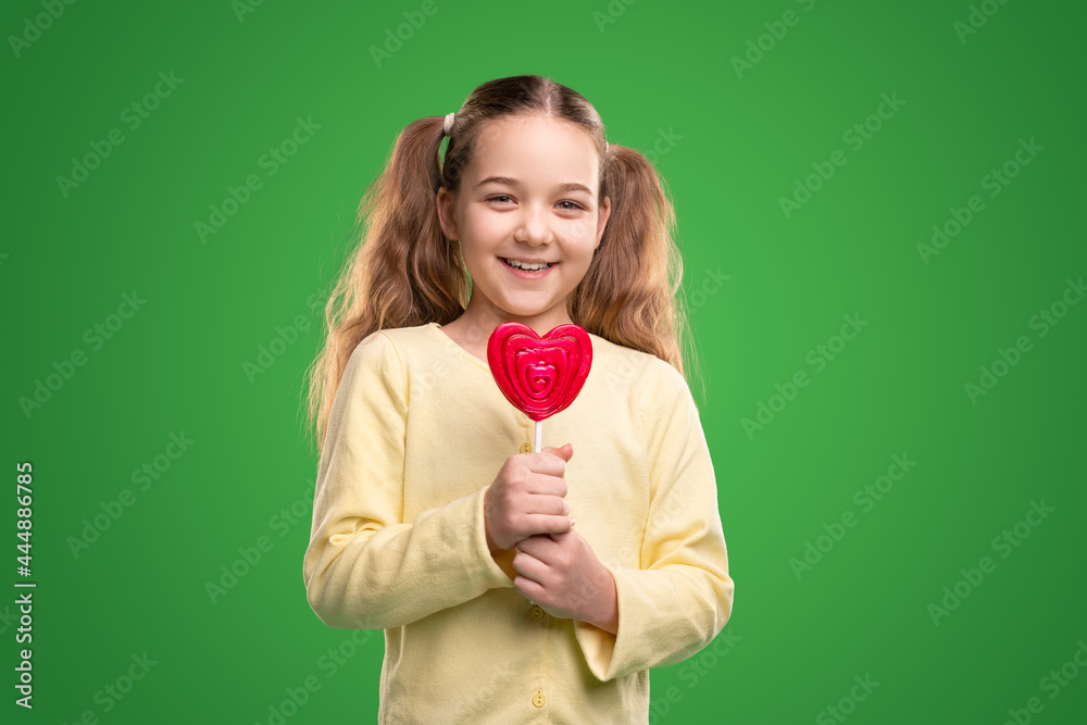 Cheerful kid with heart shaped candy Cheerful kid with heart shaped candy