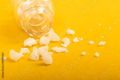 narcotic salt crystals amphetamine on yellow background photo