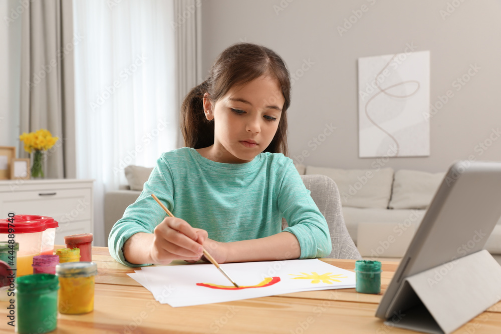 Little girl drawing on paper with paints at online lesson indoors. Distance learning Little girl drawing on paper with paints at online lesson indoors. Distance learning