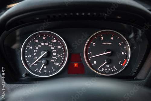 Modern Car Dashboard. Close up. Dual indicator speedometer and tachometer with white arrows.