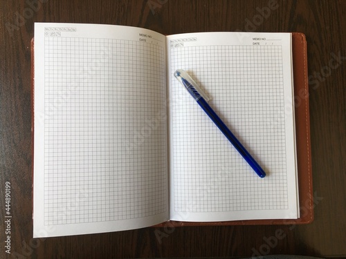 notebook and pen, note and blue pen on wooden table