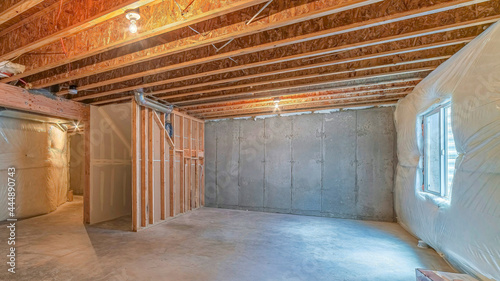 Pano Room under construction with plastic cover on wall and exposed wood beams