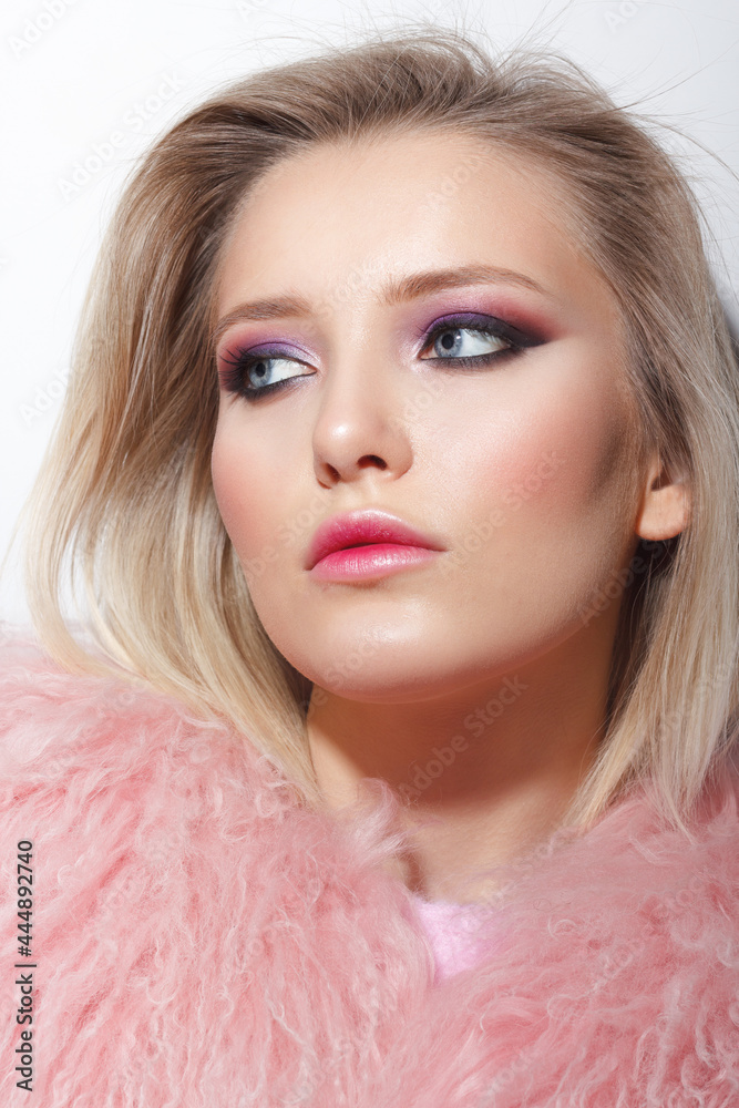Young woman wearing a fur coat in pink color