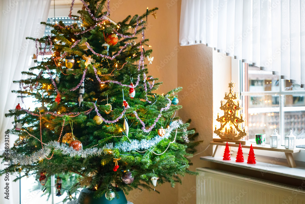 Decorated Christmas tree, indoors. Xmas tree decorations, vintage and modern. With lights illumination