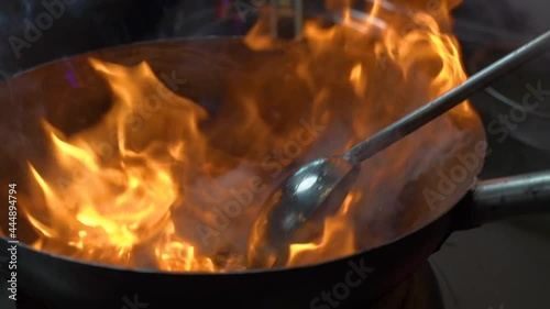 Asian style of cooking food on fire. the chef stir the noodles on in a burning bowl. wok noodles