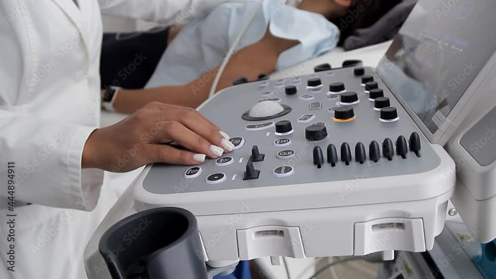 joven medico examinando a un paciente de rayos x operando en la consola mientras explica el examen al paciente