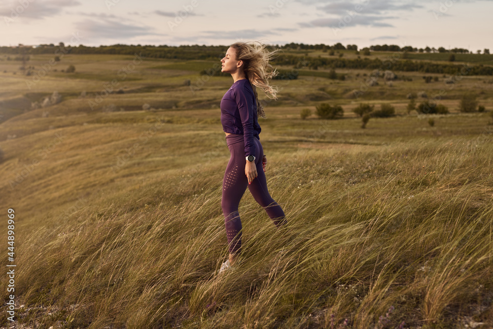 Fit woman resting after workout in field