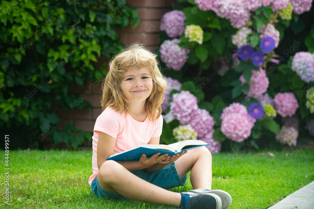 Child relax in the holiday. Kid read books on grass background. Learning concept. Child relax in the holiday. Kid read books on grass background. Learning concept.