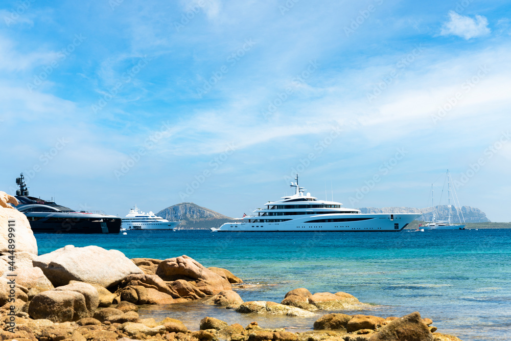 Stunning view of some luxury yachts sailing on a turquoise water during a sunny day. Cala di volpe bay,Sardinia, Italy