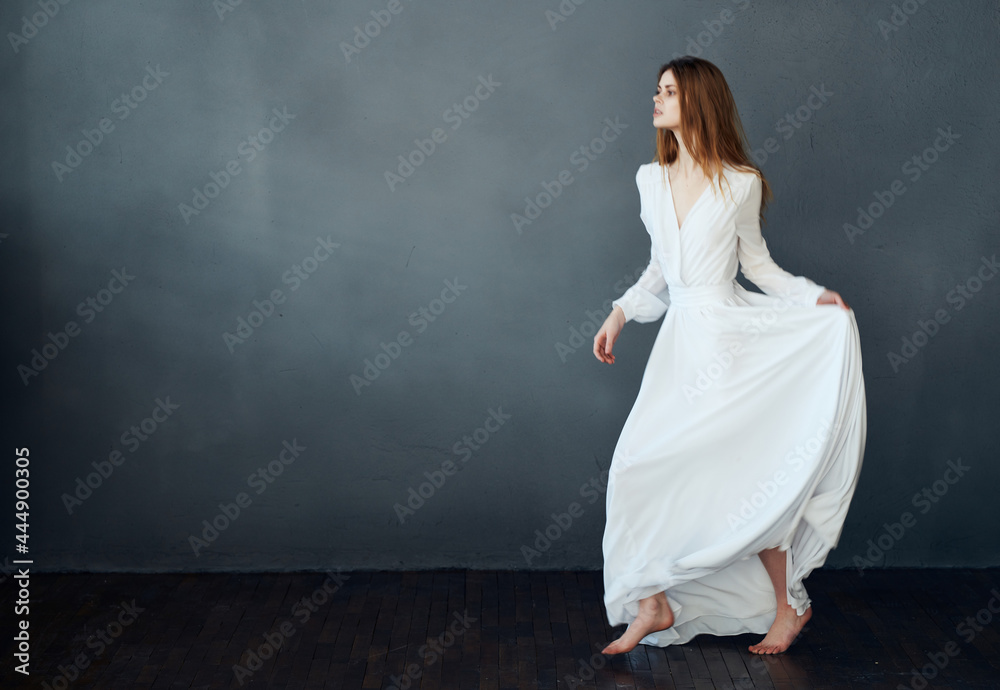 Woman in white dress barefoot dance fun dark background Woman in white dress barefoot dance fun dark background