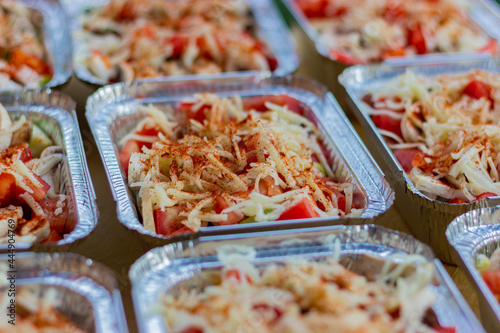 Vegetable stew sprinkled with grated mozzarella cheese in a foil baking dish. Fast food option