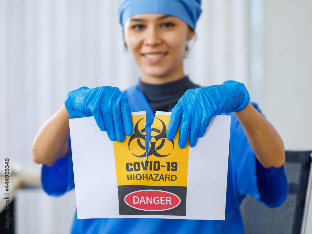 Yellow Covid19 biohazard danger paper sign was torn apart by happy