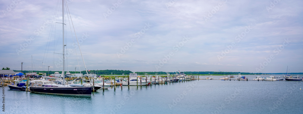 Panoramic seascape with moored boats and yachts under dramatic clouds in the summer. Post Covid-19 Summer at West Island Marina in Fairhaven, Massachusetts. Luxurious Lifestyle Image with Text Space.