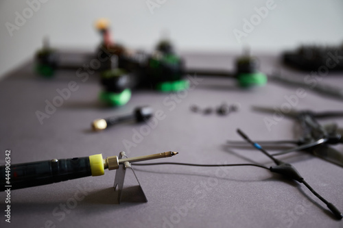 Close up of man's hands assembling a drone from parts, using tools, Preparing high-speed racing quadcopter for flight. Repair drone before training process.