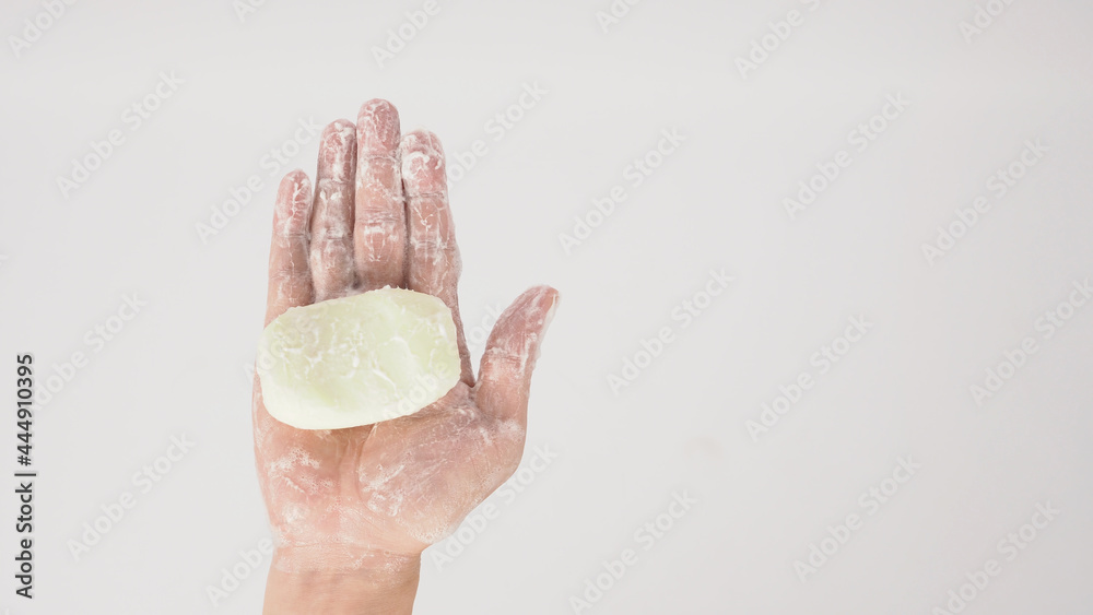 Fototapeta premium Hands washing gesture with bar soap and foam bubble on white background.