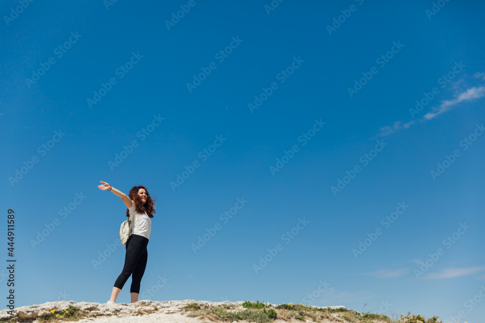 woman standing on a cliff looking at the sky of the journey woman standing on a cliff looking at the sky of the journey