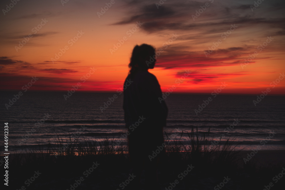 Silhouette de femme devant le coucher de soleil sur la mer