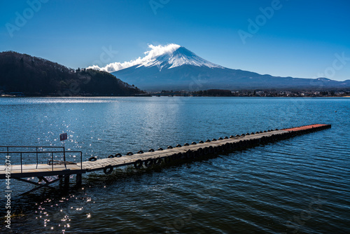 Mount Fuji from Lake Kawaguchiko in Japan. Pier across the lake and clouds across the snow covered peak of Japan's highest mountain. © Red Pagoda