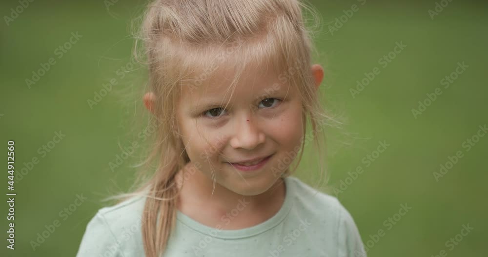 close up of happy little girl with blonde girl holding arms up in the air and having fun outside in backyard close up of happy little girl with blonde girl holding arms up in the air and having fun outside in backyard