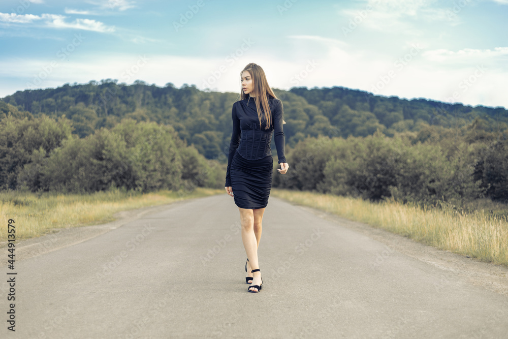 Fashion outdoor photo of beautiful woman with dark hair in luxurious sport dress posing in summer field. Fashion outdoor photo of beautiful woman with dark hair in luxurious sport dress posing in summer field.