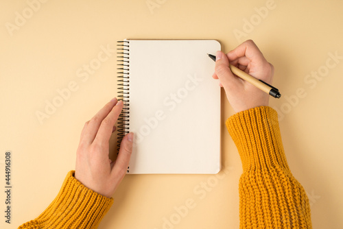 Принти на полотні First person top view photo of female hands in yellow pullover writing in spiral